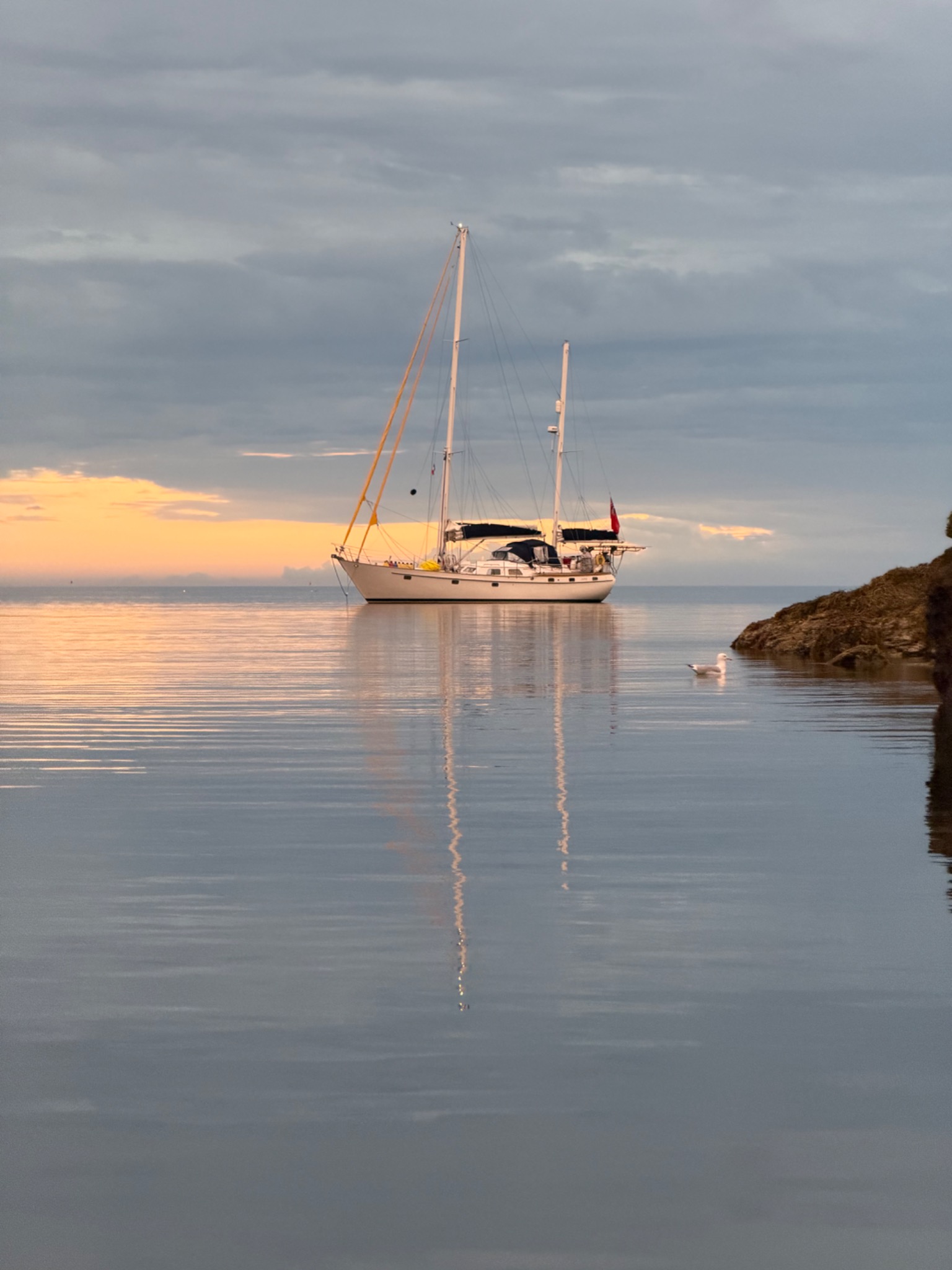 Juna at anchor at sunset, reflected in still water